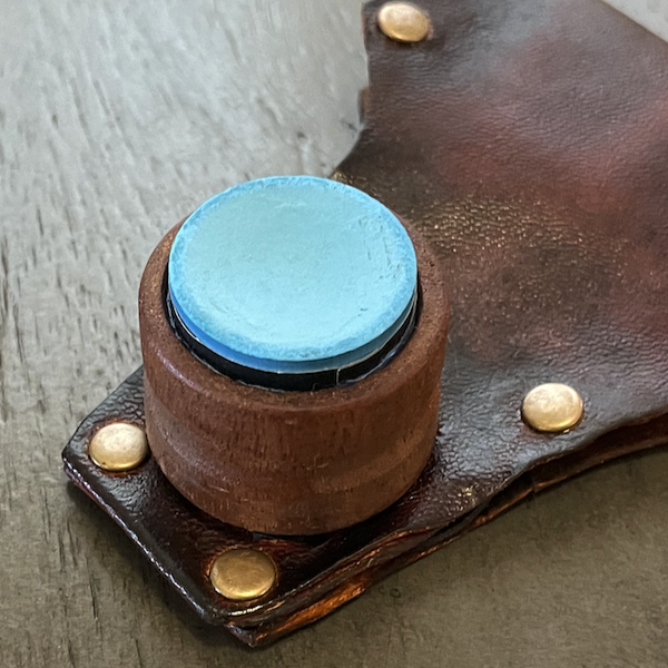 Wooden chalk holder with leather belt strap.